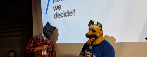 Two conference speakers with dog masks on